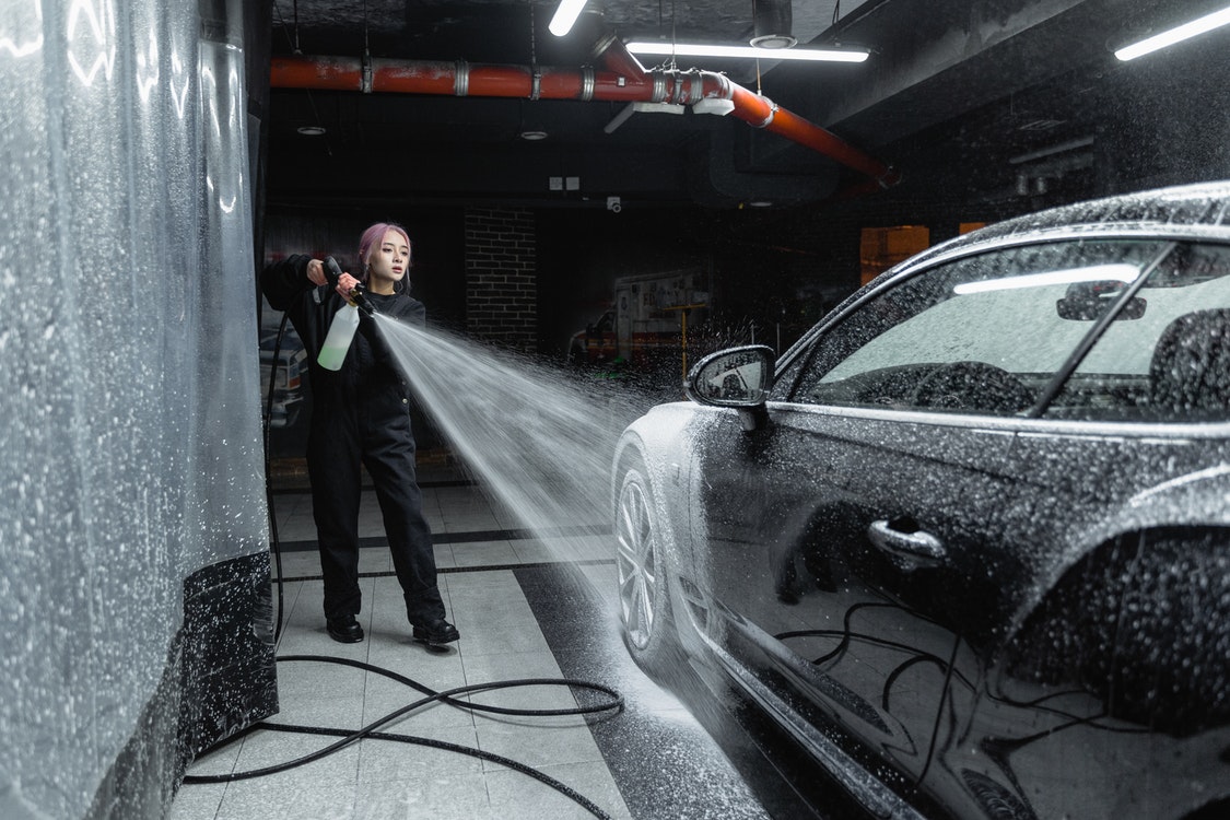 Woman cleaning car with pressure cleaning 2 - The Different Benefits of Having Epoxy Floors
